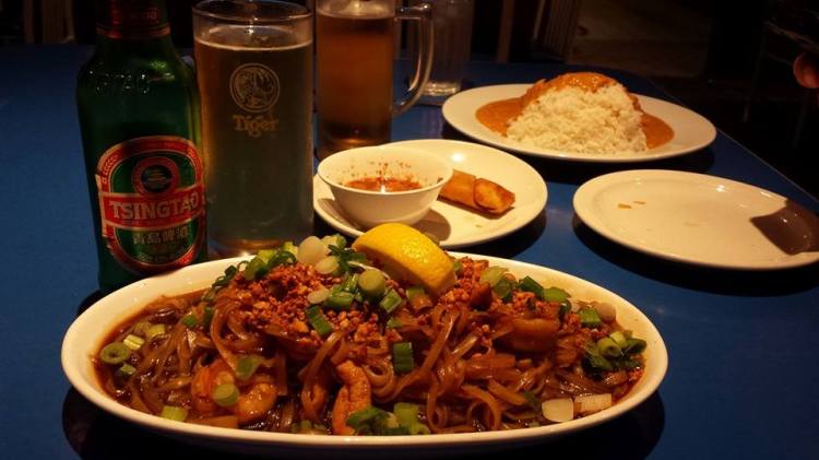 Foreground: Tsingtao, Pad Thai.  Background: Singha, spring roll, and spicy peanut chicken and rice.